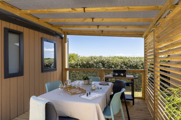 Holzterrasse mit gedecktem Tisch, Blick auf den Garten