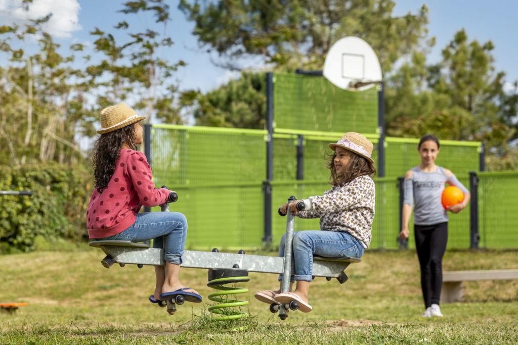 Enfants jouant à la balançoire dans un parc.